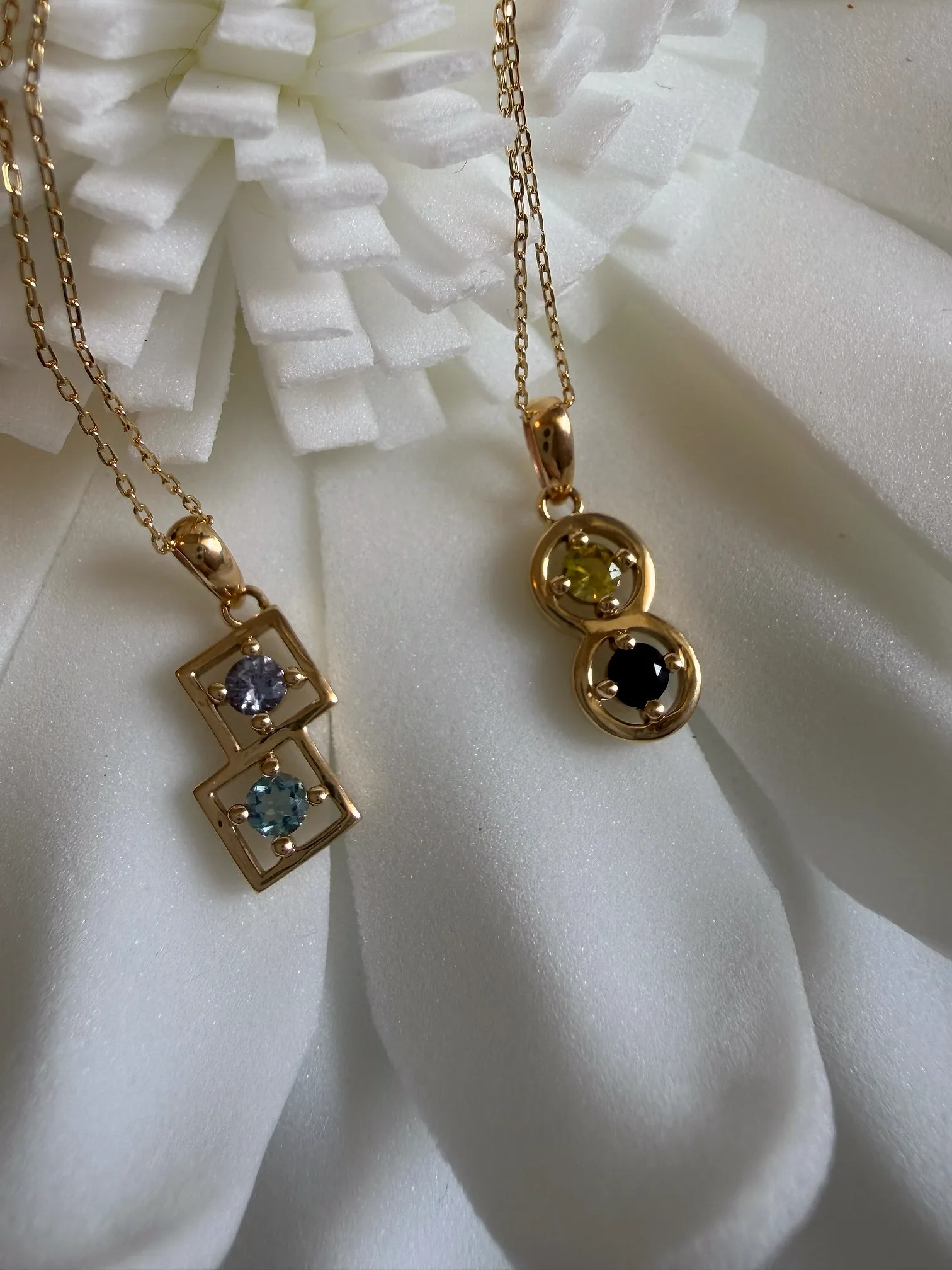 白い花の器に掛けた、ゴールドのカップリングネックレス2本