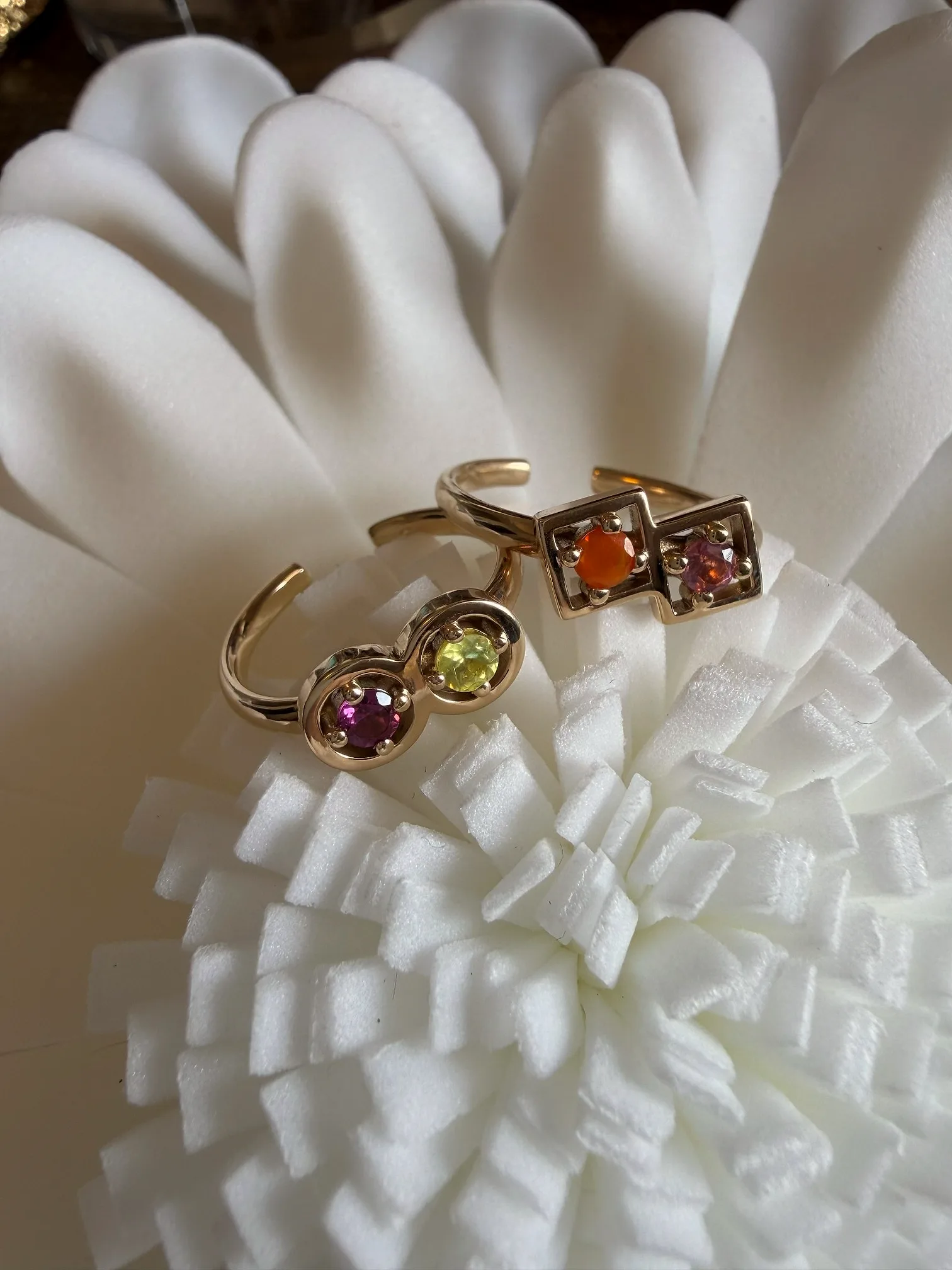 白い花の器に置いた、ゴールドのカップリングリング2点
